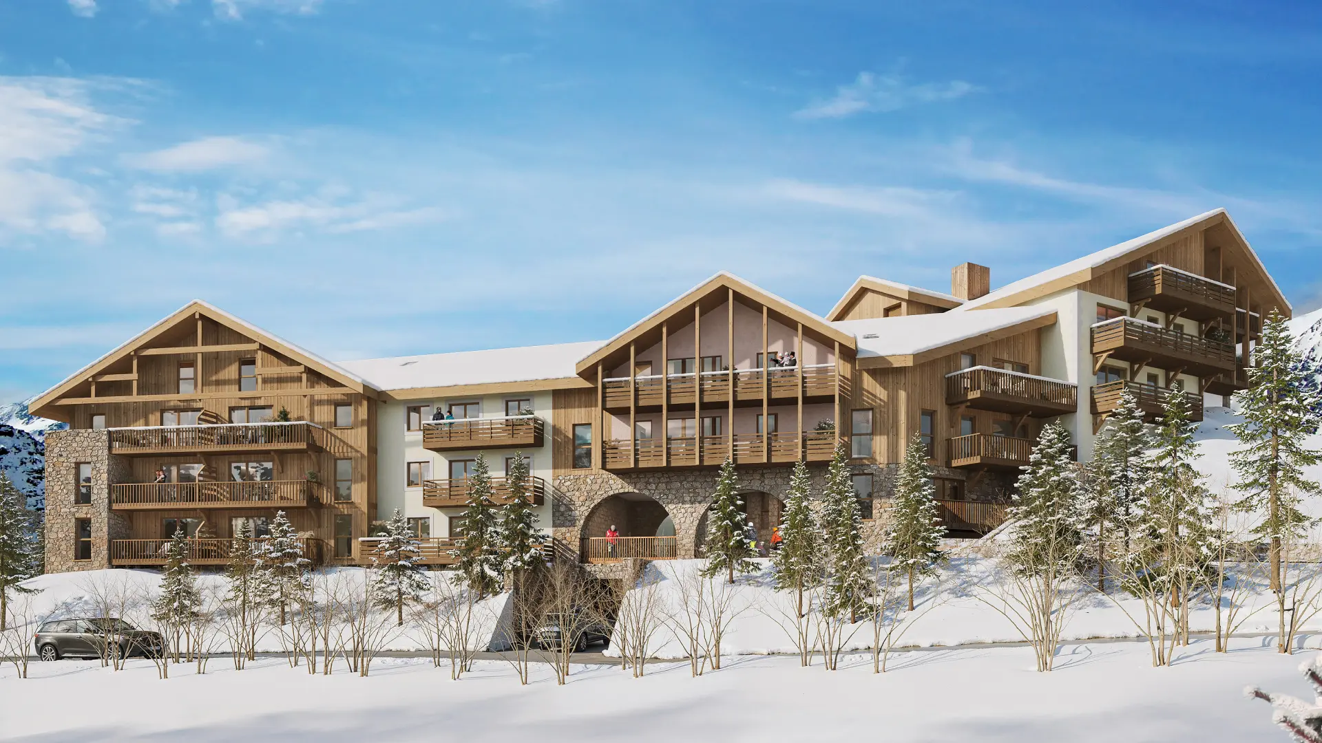 Cette image de rendu architectural présente un programme immobilier de montagne de conception contemporaine, parfaitement intégré dans son environnement hivernal. Le bâtiment se compose de plusieurs volumes reliés, créant une composition harmonieuse et dynamique. L'architecture conjugue habilement tradition et modernité : toits à double pente caractéristiques de l'habitat alpin, façades habillées de bois naturel clair qui se patinera avec le temps, et soubassements en pierre apparente rappelant les constructions traditionnelles de montagne. Les larges baies vitrées et les balcons filants en bois apportent une touche contemporaine tout en maximisant les vues sur le paysage. La résidence s'organise sur plusieurs niveaux, avec de généreux balcons à chaque étage offrant des espaces extérieurs privatifs. Le rez-de-chaussée présente des passages voûtés créant des cheminements couverts et un lien visuel avec le versant arrière. De jeunes conifères ponctuent l'aménagement paysager enneigé, renforçant l'ancrage dans le territoire alpin. L'ensemble respire la qualité architecturale et l'attention portée à l'intégration paysagère, caractéristiques des programmes immobiliers haut de gamme en station de ski.