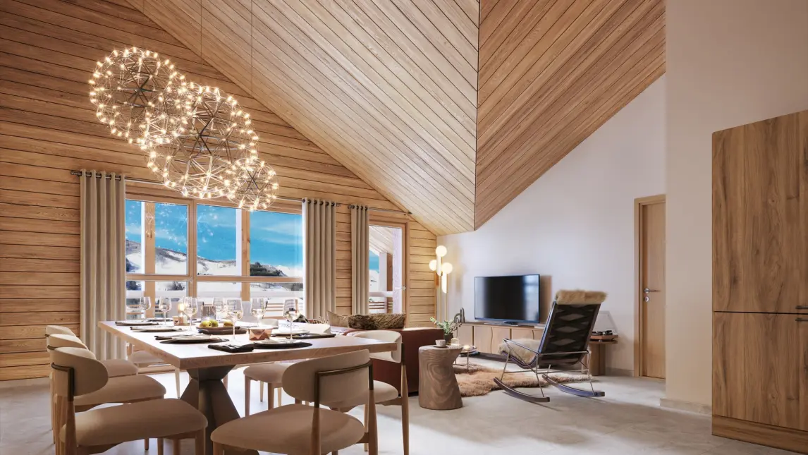 Cette image présente un espace de vie moderne et élégant dans un logement alpin haut de gamme. L'architecture se distingue par un plafond cathédrale entièrement habillé de lames de bois clair disposées en diagonale, créant une atmosphère chaleureuse et graphique. L'espace à vivre décloisonné réunit la salle à manger et le coin salon. Une table à manger design accueille six chaises contemporaines au revêtement beige, surmontée par un luminaire sculptural composé de plusieurs sphères lumineuses en suspension. La grande baie vitrée à croisillons bois laisse entrer une lumière naturelle abondante et offre une vue spectaculaire sur les montagnes enneigées et la station. Le coin salon affiche un style épuré avec un fauteuil à bascule design noir, un meuble TV en bois naturel et des touches décoratives sobres. Les murs blancs contrastent harmonieusement avec le bois omniprésent, tandis que le sol en carrelage clair renforce la luminosité de l'ensemble. L'ensemble illustre parfaitement l'équilibre entre tradition alpine (matériaux naturels, volumes généreux) et design contemporain (lignes épurées, mobilier moderne), caractéristique des résidences de standing en montagne.